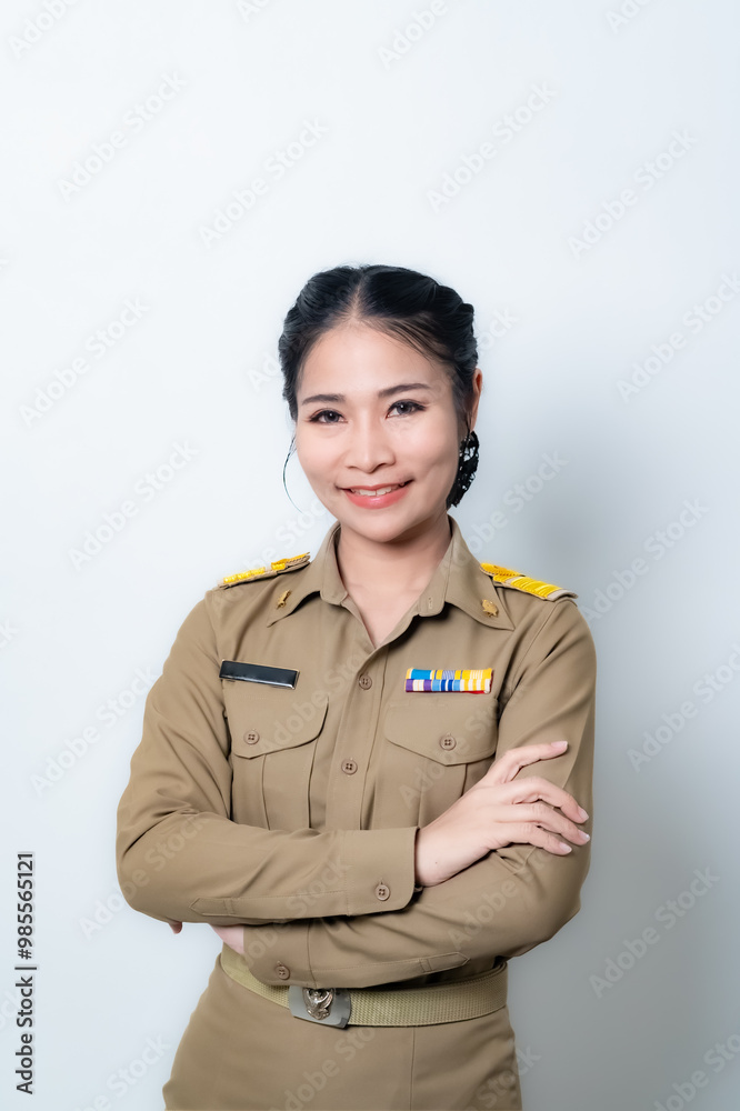 Female Thai government officer in khaki uniforms smiling. Beautiful woman doing winner gesture with arms raised isolated over white background. Concept Female Thai government officer in khaki uniforms smiling. Beautiful woman doing winner gesture with arms raised isolated over white background. Concept