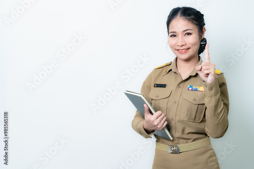 Female Thai government officer in khaki uniforms smiling. Beautiful woman doing winner gesture with arms raised isolated over white background. Concept