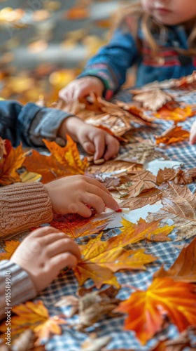 Children engaging in an autumn craft activity, arranging colorful leaves on a table with a checkered cloth.