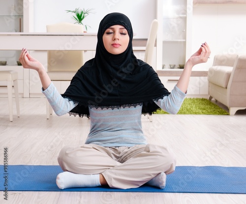 Obraz na płótnie Young woman in hijab doing exercises at home w salonie