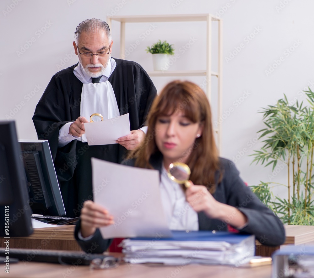 Old male judge and his young secretary in the office Old male judge and his young secretary in the office