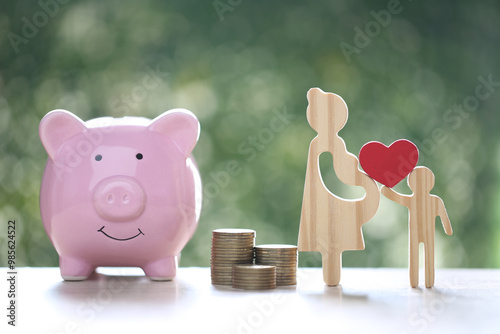 Pregnant woman with piggy bank and gold coin money on natural green background,Save money for prepare in future and newborn baby concept photo