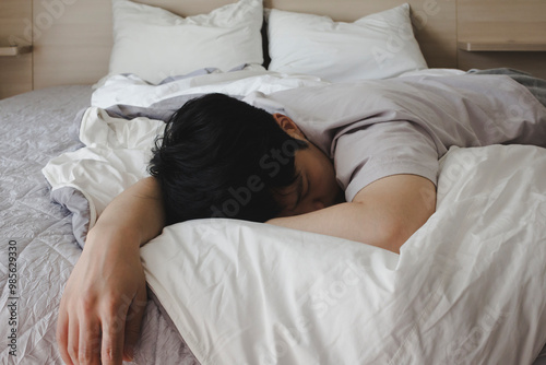 Fotografie 침대 위에 엎드려 있는 남성 청년 한 명