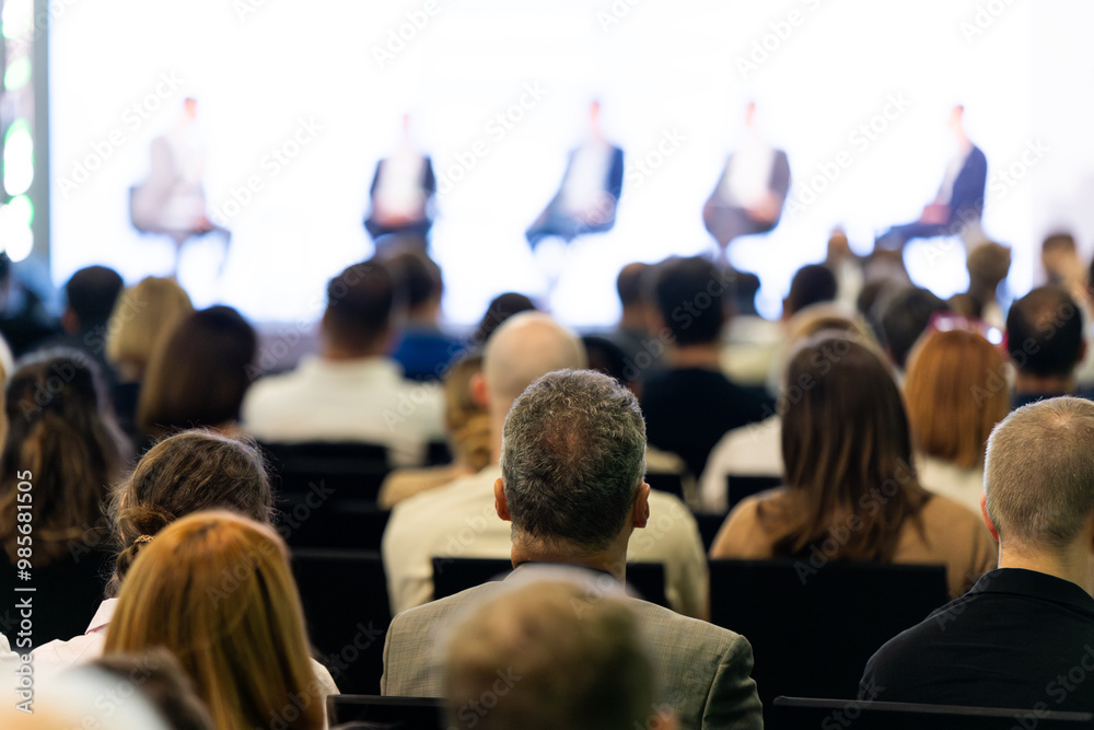 Rear view of the audience at a business conference meeting event listening to the speakers speech