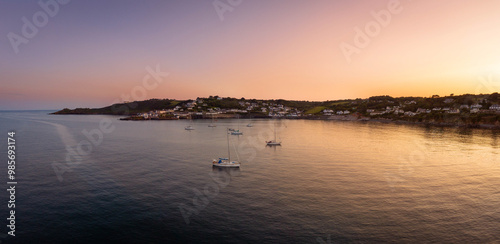 Sailing yachts take shelter for the evening at sunset in Coverack. photo