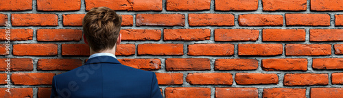 A businessman standing in front of a brick wall with Tariffs painted on it, tariff wall, trade war visual