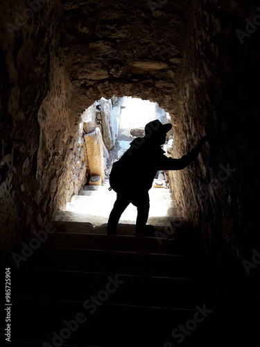 a man is standing in a cave with a shadow on the wall.