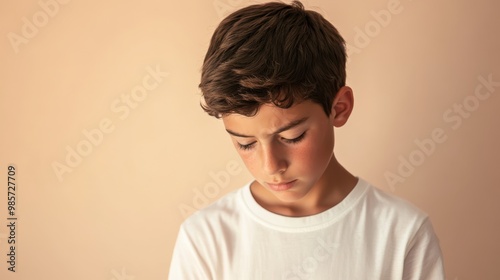 Boy with Regret Looking Down in Soft Lighting