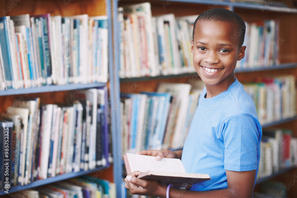Black boy, library and smile for reading book at elementary school for literacy, knowledge and information. Student, kid and happy on portrait for education, novel or literature for brain development Black boy, library and smile for reading book at elementary school for literacy, knowledge and information. Student, kid and happy on portrait for education, novel or literature for brain development