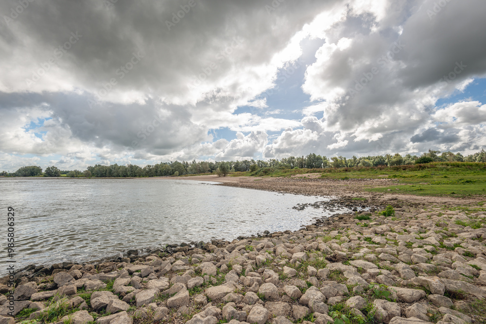 Dark rain clouds above the banks of the Dutch river Waal.