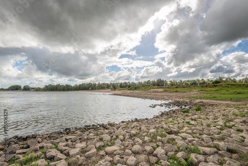 Obraz na płótnie Dark rain clouds above the banks of the Dutch river Waal. w salonie
