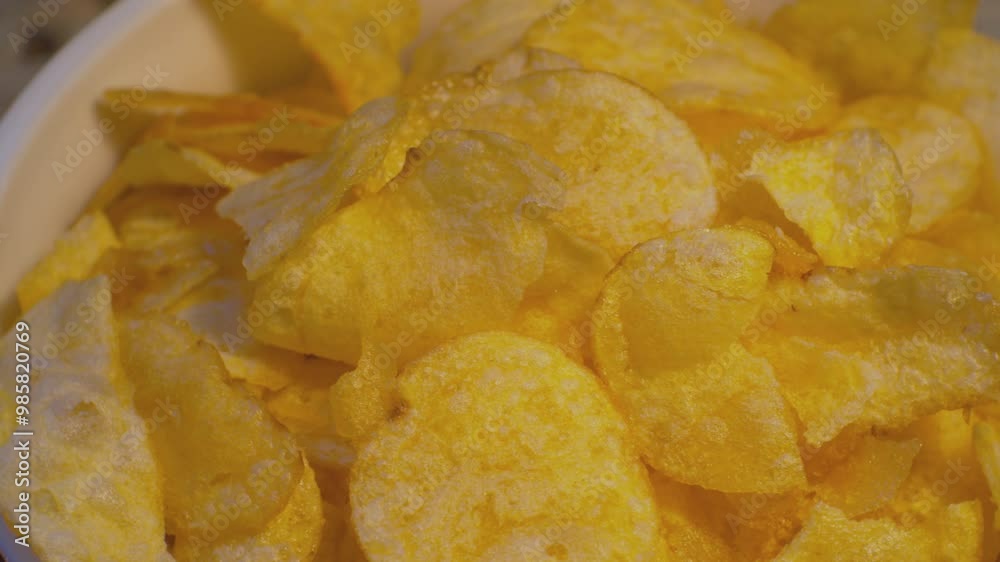 A bowl of delicious potato chips slowly spins. Food shot close-up. Shallow depth of field. A bowl of delicious potato chips slowly spins. Food shot close-up. Shallow depth of field.
