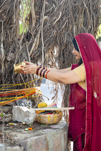 devotee worshiping the holy banyan tree with offerings at day