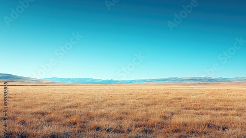 A vast landscape featuring clear blue sky and golden grasslands stretches into horizon, evoking sense of tranquility and openness