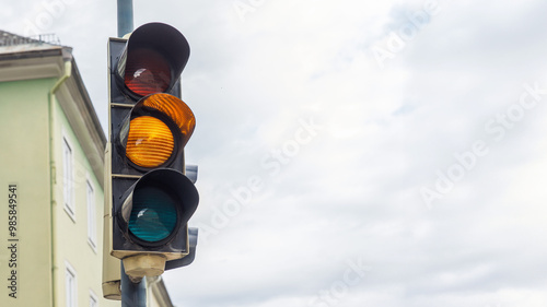 Traffic light showing red, yellow, and green lights at city intersection, urban transportation concept photo