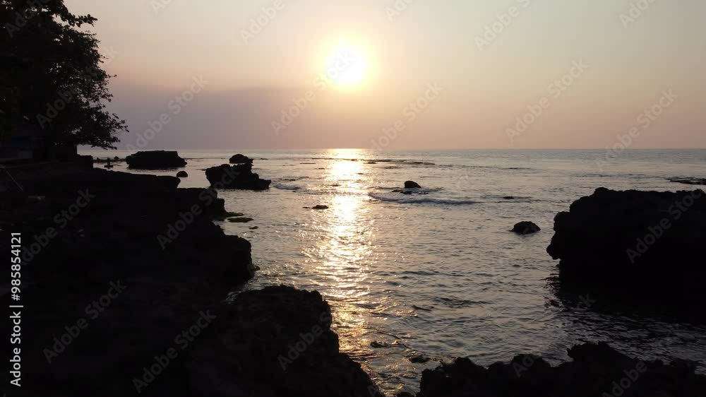 Sunset at Anyer beach, Indonesia. Aerial view of sunset or sunrise on the sea, dramatic sunlight reflection on the beach. Sunset at Anyer beach, Indonesia. Aerial view of sunset or sunrise on the sea, dramatic sunlight reflection on the beach.