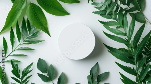 White round podium for presenting natural organic cosmetics, laid on green eco-friendly leaves in a minimalist flat lay background.  photo