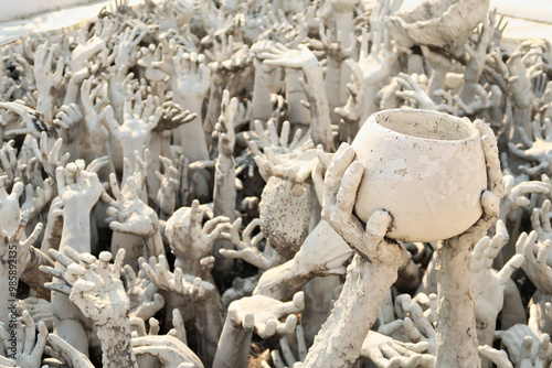 Bilde på lerret A sculpture of two hands holding a bowl surrounded by hundreds of outreaching ha