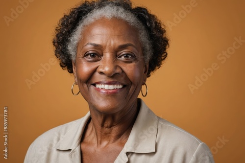 Full framed very close face portrait of a smiling senior black woman with amber eyes looking at the camera, studio shot,amber background.