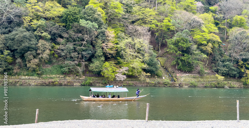 Boat ride in Kyoto Japan. Tourists in a traditional wooden boat in Uji river in spring