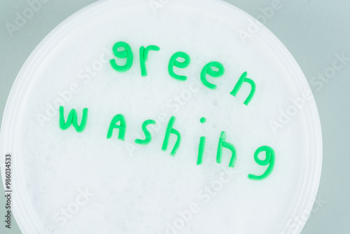 Creative concept of greenwashing. Message in soapy water in a basin on a gray background. Paint a misleading picture of their environmental friendliness. isolated. top view photo