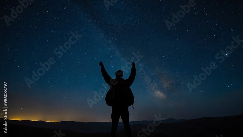 A starry night sky with a silhouette of a person gazin