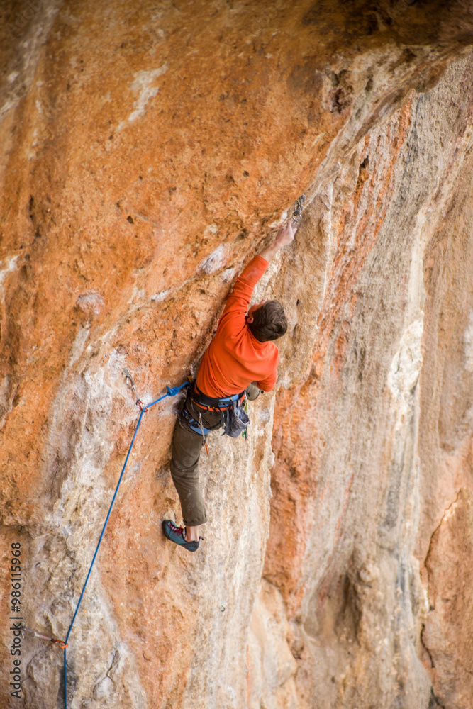 A rock climber ascends to the summit via a difficult route. A rock climber ascends to the summit via a difficult route.