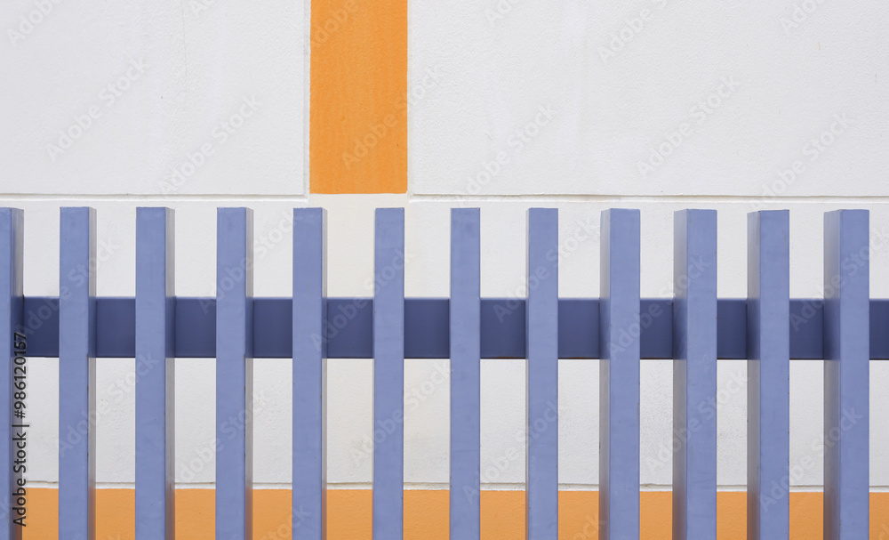 Gray artificial wooden fence in front of beige concrete wall of vintage house Gray artificial wooden fence in front of beige concrete wall of vintage house