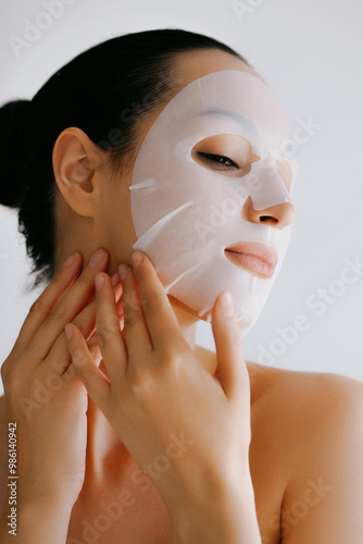 Young woman applying white cosmetic moisturizing mask