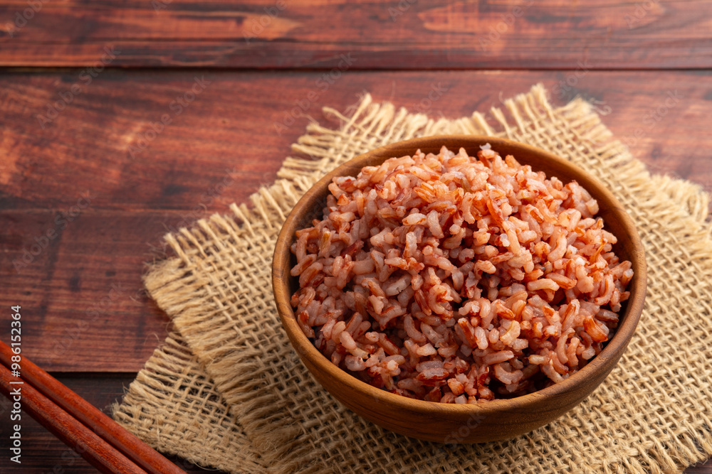 Cooked Thai Organic Red Jasmine Rice in wooden teak bowl.semi-milled rice.including fiber, B vitamins, and minerals such as iron and magnesium Cooked Thai Organic Red Jasmine Rice in wooden teak bowl.semi-milled rice.including fiber, B vitamins, and minerals such as iron and magnesium