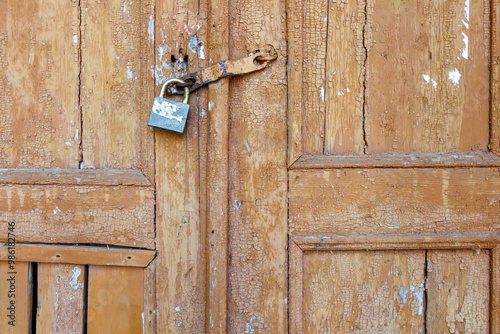 Old wooden door with rusty metal padlock close up photo