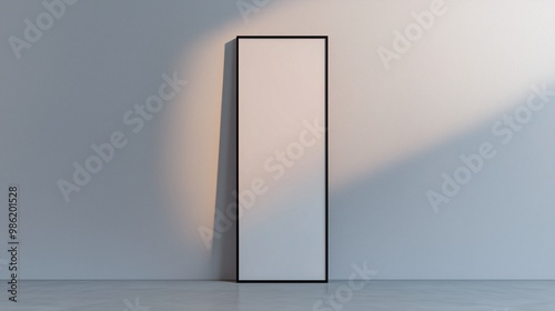 A tall, vertical frame standing alone on a pale grey wall with subtle top-down lighting that highlights the smoothness of the wall.