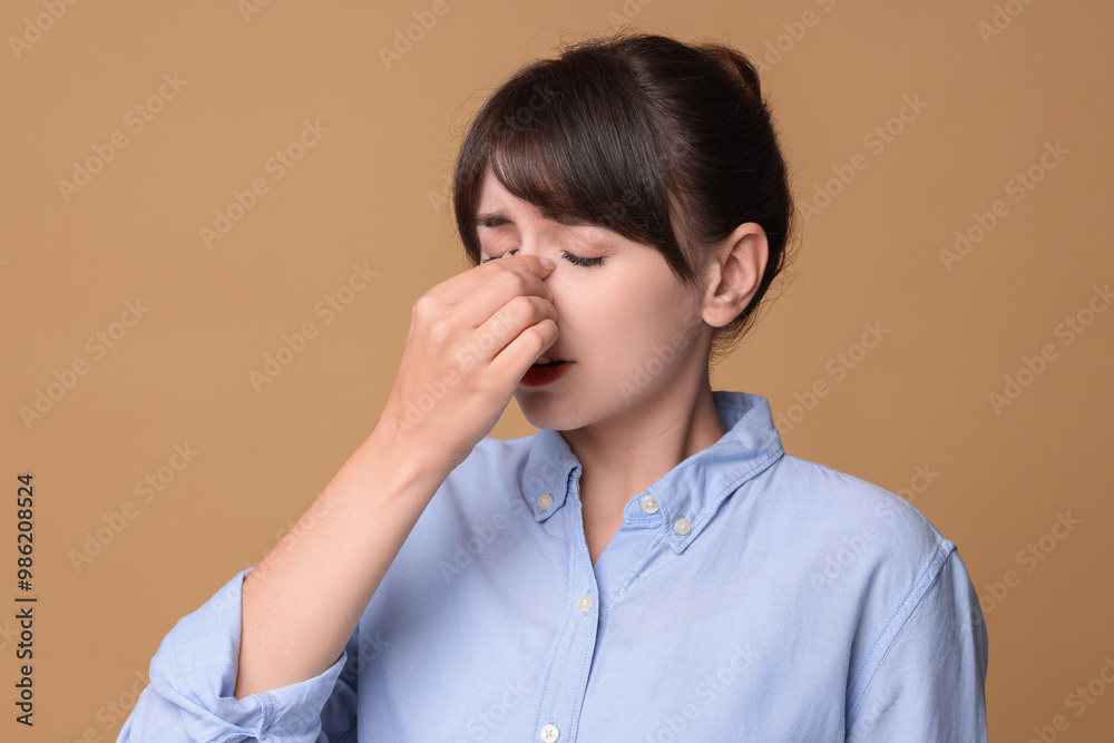 Woman suffering from sinusitis on beige background Woman suffering from sinusitis on beige background