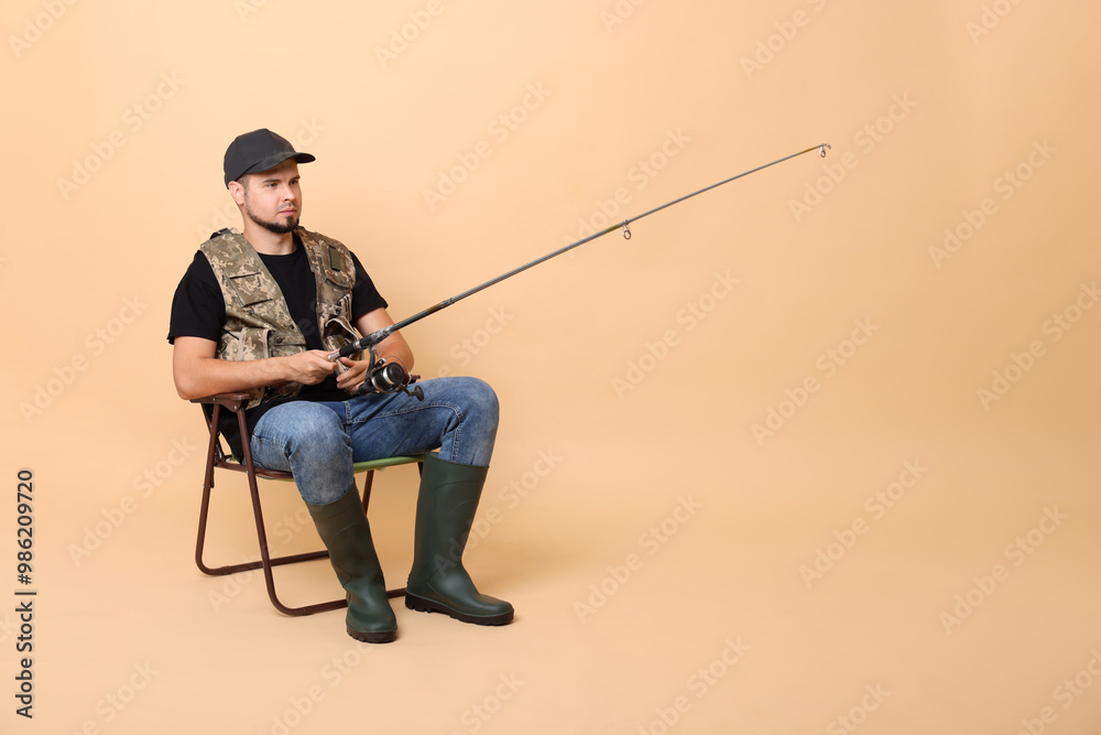 Fisherman with rod fishing on chair against beige background