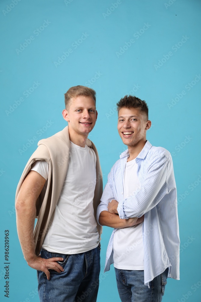 Portrait of happy brothers on light blue background Portrait of happy brothers on light blue background