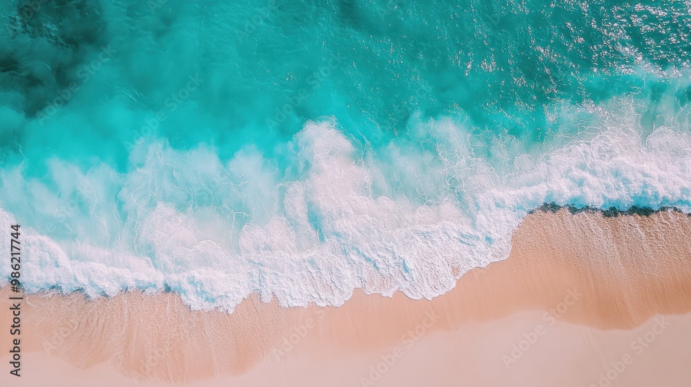 Top view of an ocean beach with turquoise water and white foamy waves crashing on a sandy shore. Top view of an ocean beach with turquoise water and white foamy waves crashing on a sandy shore.