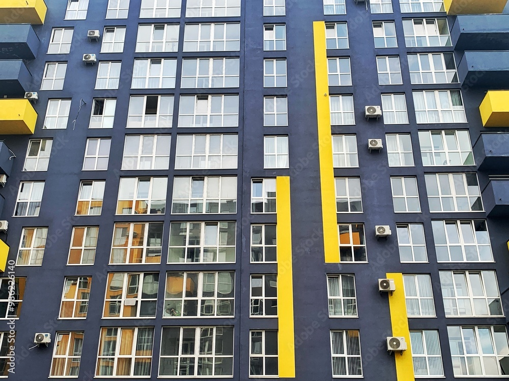 Fototapeta premium Architecture Background. Detail New high-rise Building or House Modern facade with windows. Contemporary geometrical architectural design backdrop. Real Estate concept. Yellow and Gray-Dark blue color