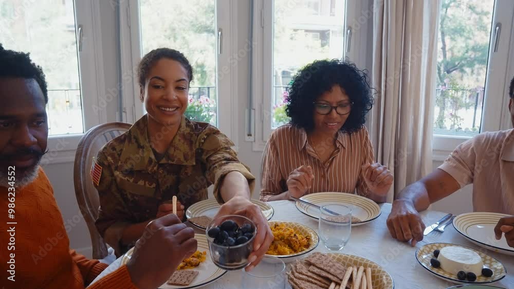 Cinematic video of a woman coming back home from the army military service in the us. Family reunited at lunch time indoor in a beautiful american house.