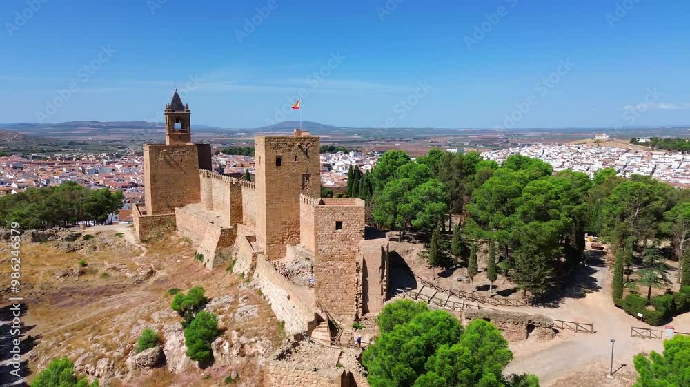 Drone flight around the Alcazaba fortress of Antequera, Spain located on a hill and surrounded by historic town with typical andalusian white houses and old churches. Mountains in the background. Drone flight around the Alcazaba fortress of Antequera, Spain located on a hill and surrounded by historic town with typical andalusian white houses and old churches. Mountains in the background.