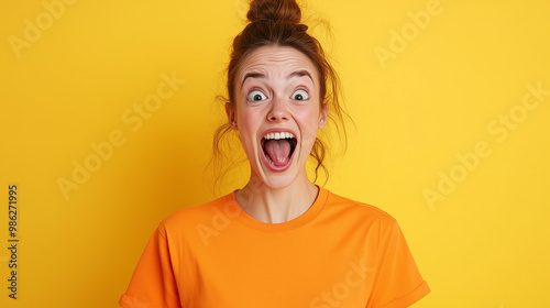 A young woman with a surprised expression, mouth wide open, looking directly at the camera against a bright yellow background.