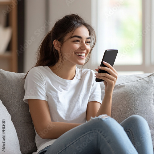 Smiling Latina woman resting on cozy sofa with smartphone, making call, check personal organizer using mobile application, enjoy remote communication with friend, ordering delivery services at home