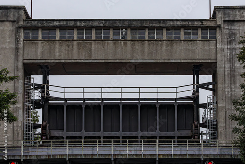 Bridge with raised gate at entrance or exit of Bosscherveld lock, building and metal structure, river Meuse and Zuid-Willemsvaart canal, cloudy summer day in Maastricht, South Limburg, Netherlands photo