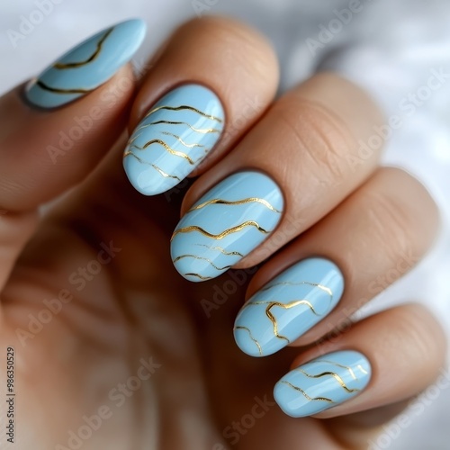 Elegant blue nail art design featuring wavy golden patterns for a stylish and trendy look. photo