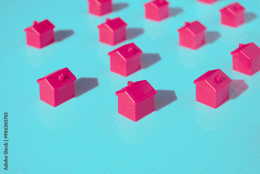 Real estate industry. House searching concept. Search for housing, apartments. Line of pink houses with deep shadows on a blue background. Space for text. Banner. Template copy space. 3d rendering