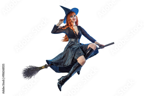 Halloween Witch flying on a broomstick. Female wizard fairy character for All Saints' Day. Fantasy gothic red-haired sorceress girl dressed in black carnival costume