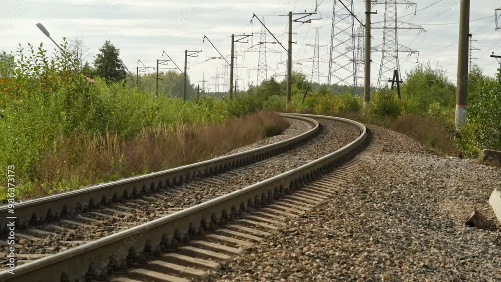 Railway. A picturesque view of the curved railway tracks, surrounded by lush greenery, as well as urban elements. Railway. A picturesque view of the curved railway tracks, surrounded by lush greenery, as well as urban elements.