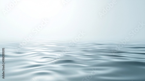 Gentle waves rippling on a vast ocean under a clear blue sky, creating a peaceful atmosphere with sunlight reflecting off the water. Perfect for a calm day outdoors