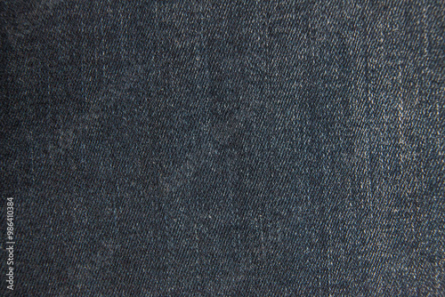 Macro closeup: dark blue denim fabric with intricate weave pattern and subtle variations in texture. Diagonal lines and tiny fibers create a rich tactile surface.
