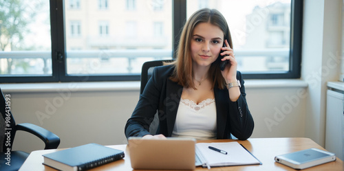 A confident businesswoman is discussing a new strategy over the phone in a bright and productive office. 