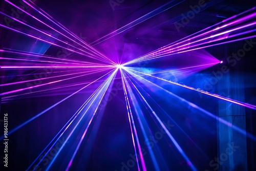 Blue and violet beams of bright laser light shining on black background